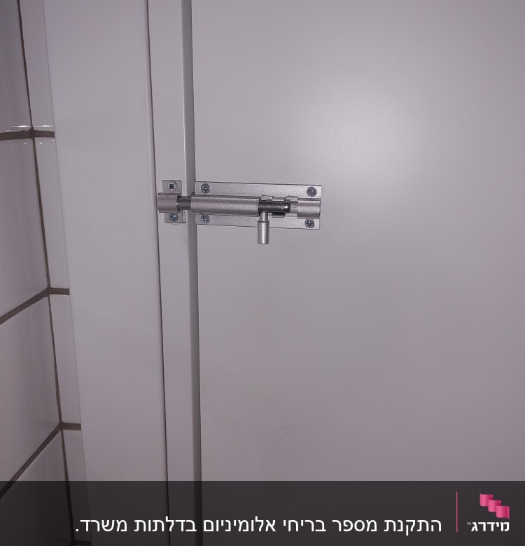 בריח מתכת על דלת לבנה